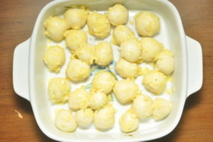 cheesy garlic pull apart rolls arranged in baking tray.