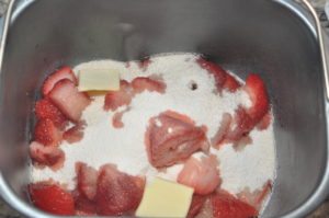 strawberry jam ingredients in bread machine pan.