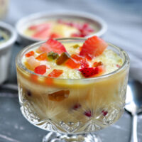 indian custard in a bowl with fruits and tutti frutti.
