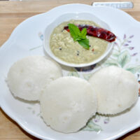 idli in a plate with chutney.