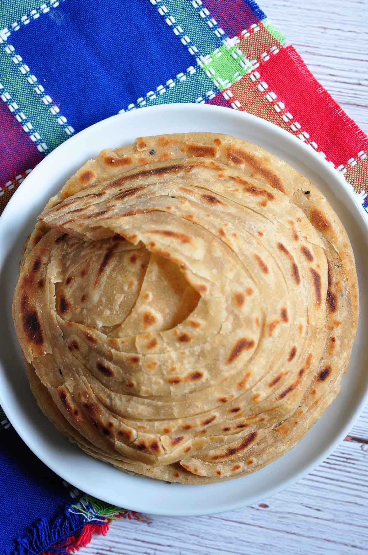 Layered flaky flat bread in a plate.