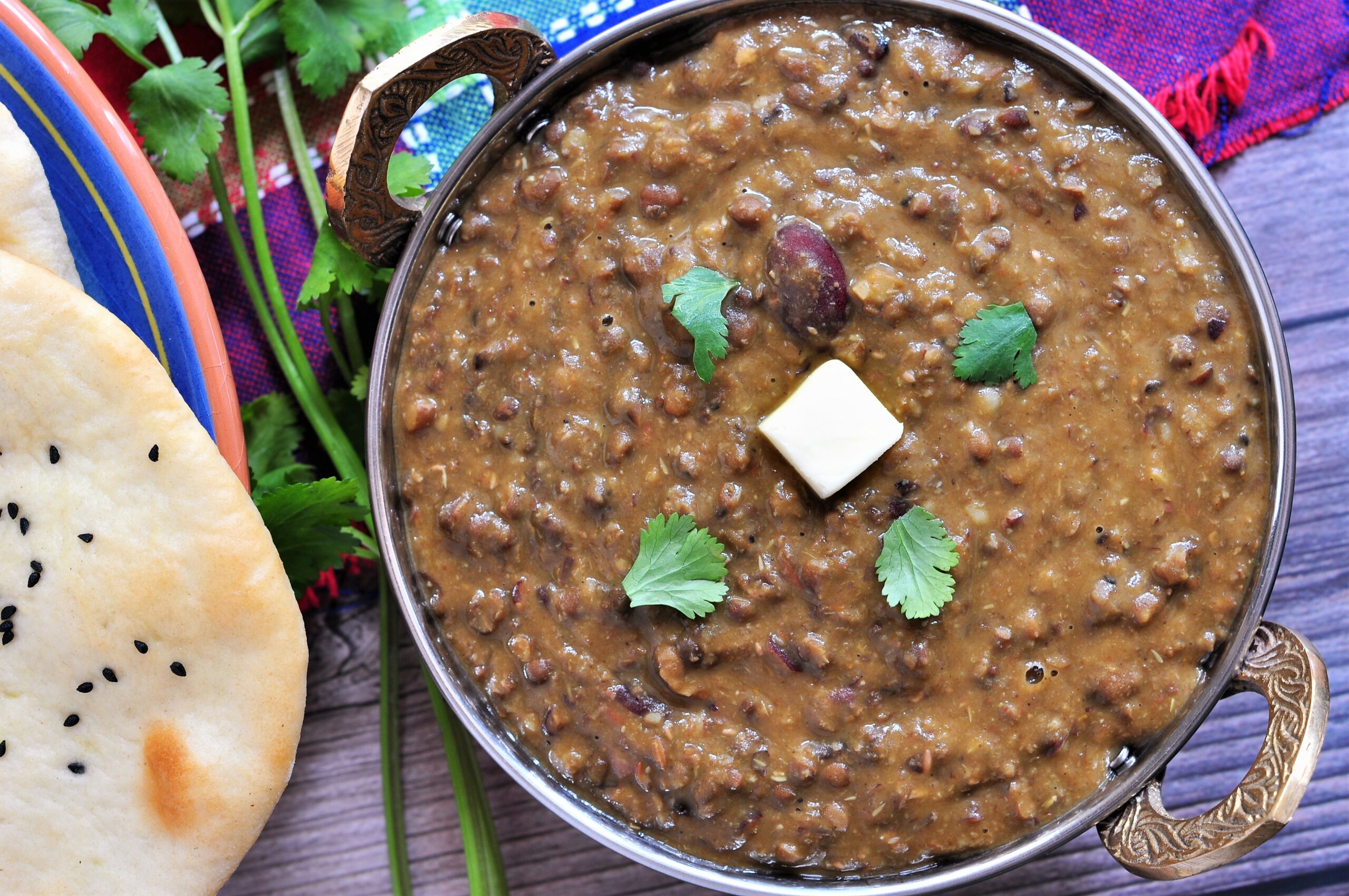 Dal Makhani in a serving wok and garnished with cilantro and butter.