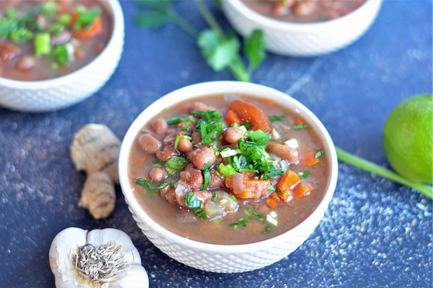 Pinto beans soup in a bowl, garnished with cilantro.