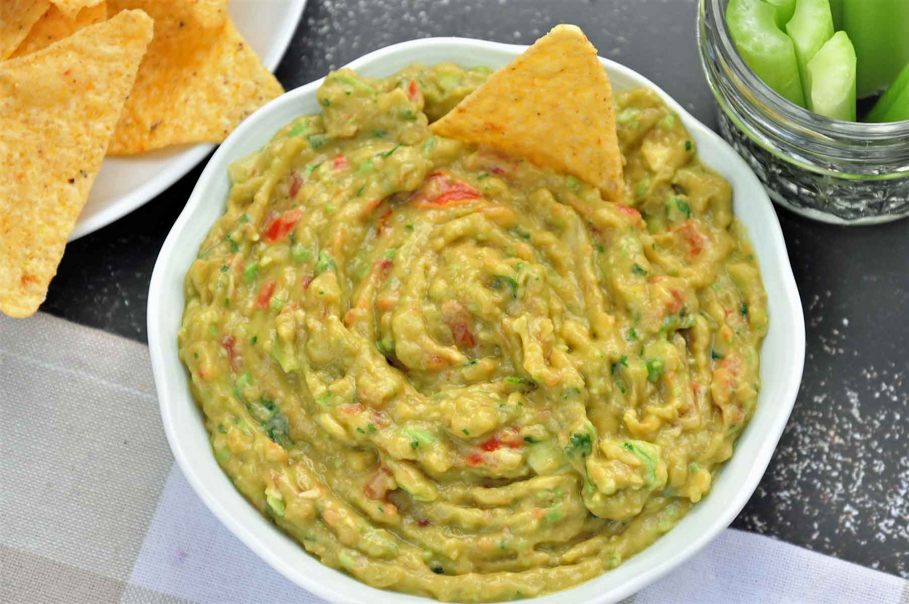 Guacamole served in a bowl with tortilla chips.