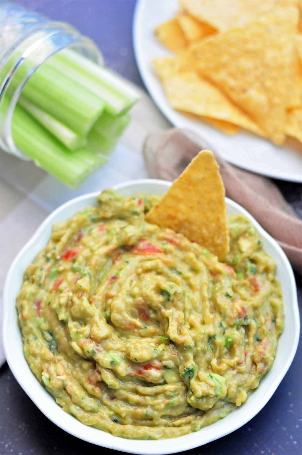 Guacamole served in a bowl with tortilla chips.