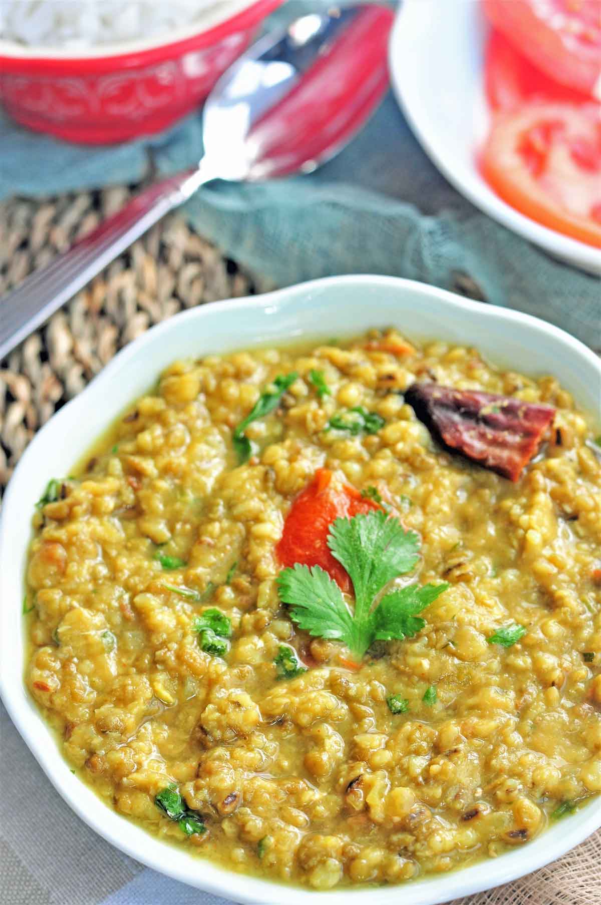 Green moong dal served in a bowl, garnished with cilantro leaves.