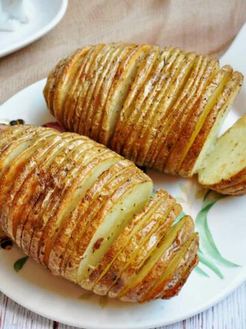 Air fried Hasselback potatoes served on a cheese board.