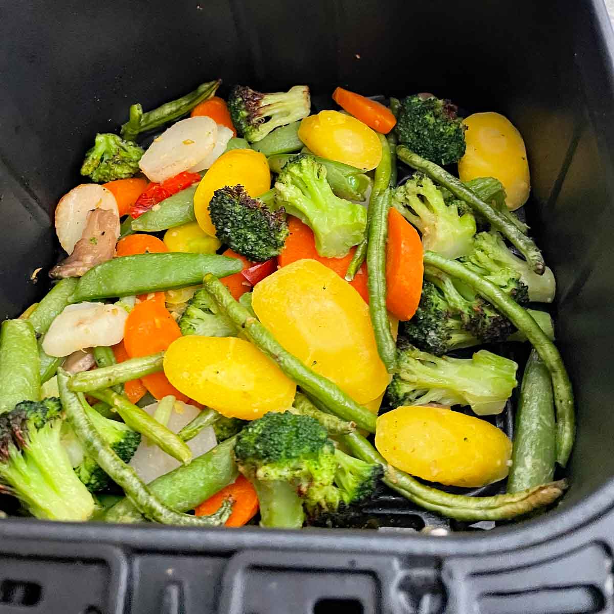 Cooked mix veg in air fryer basket.