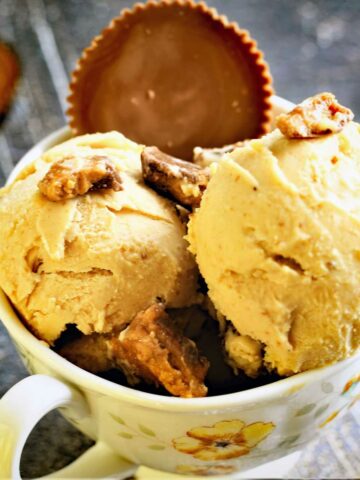 Peanut butter ice cream scoops served in a bowl with Reese's topping.