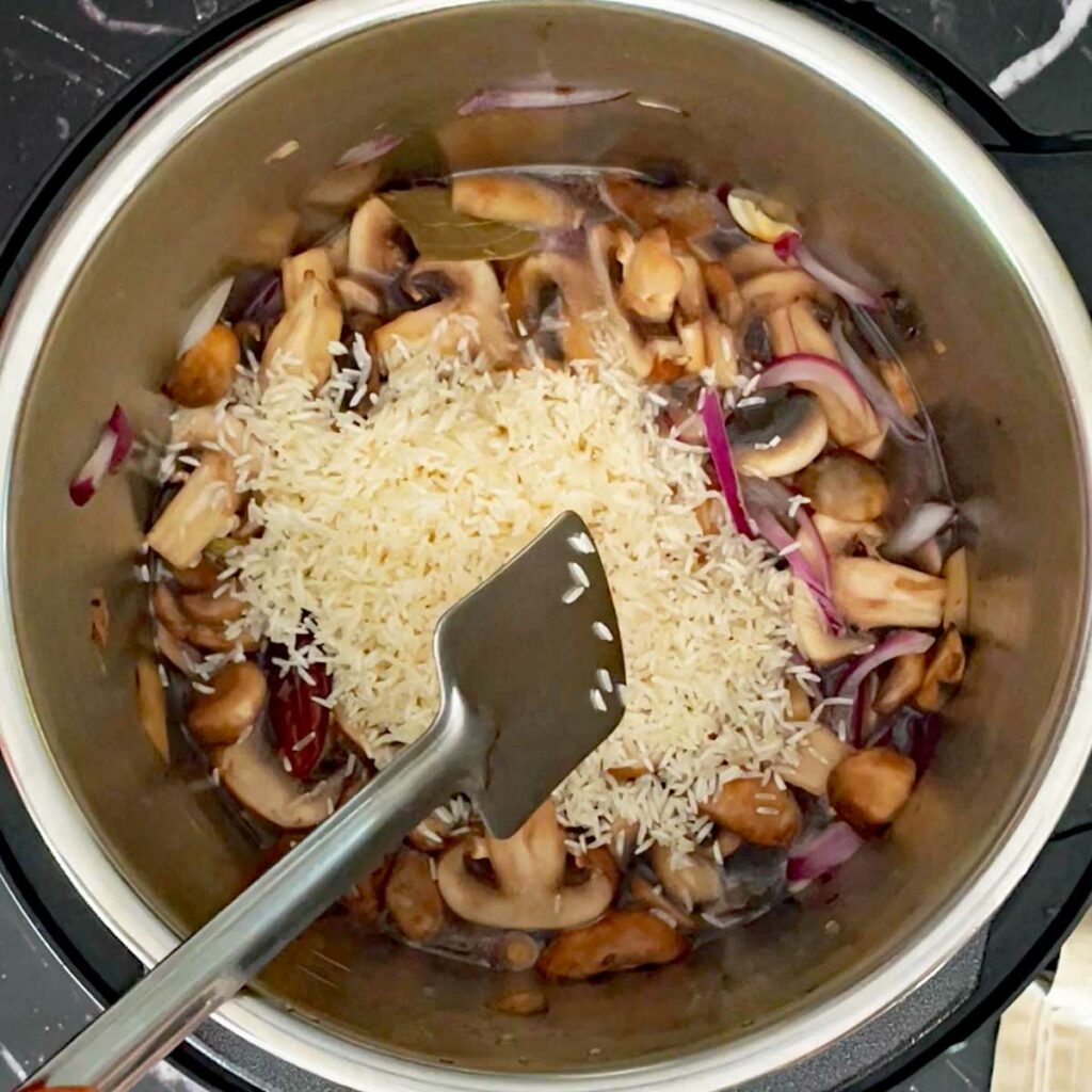 Add rice to sautéed mushroom.
