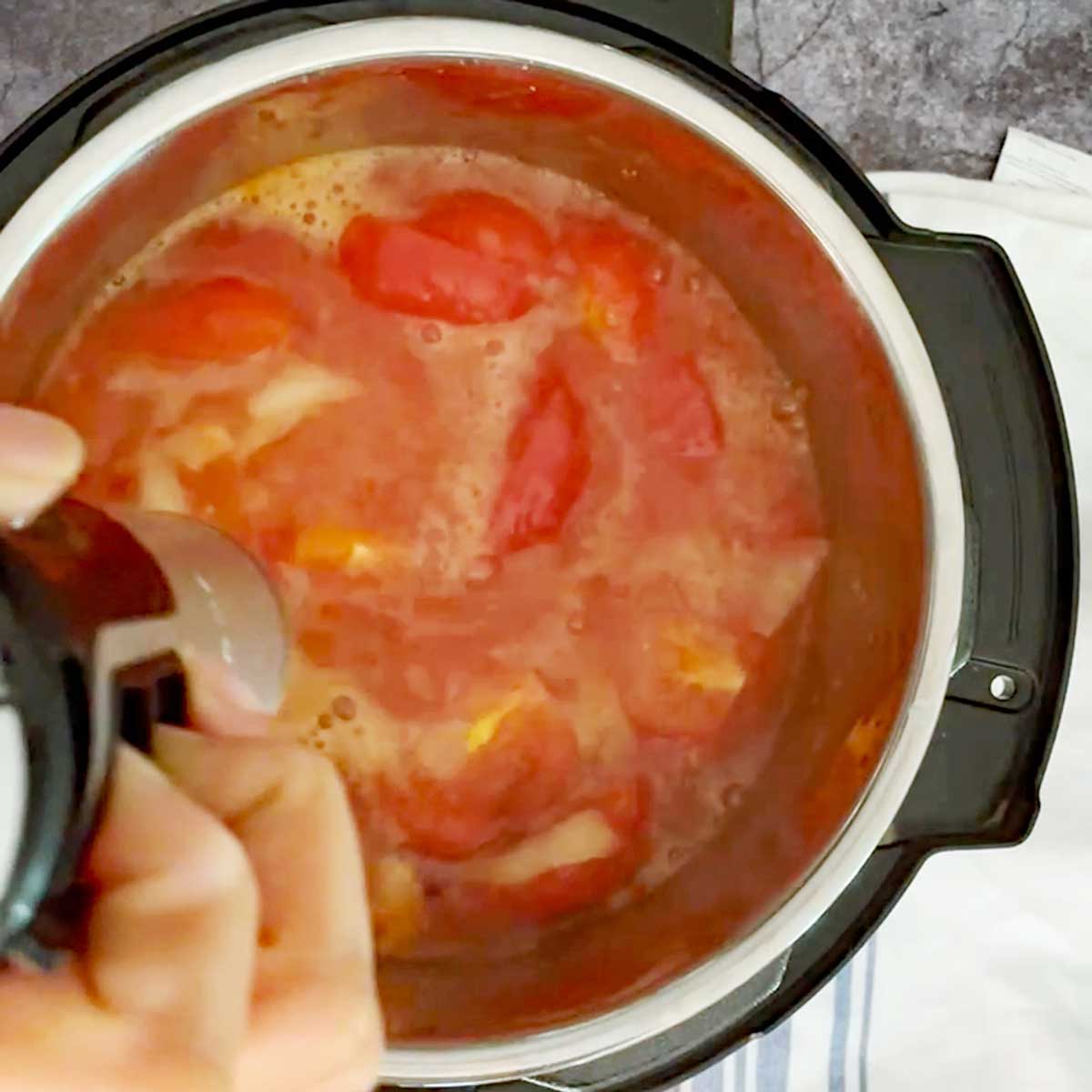 Blending tomato ketchup ingredients after cooking.