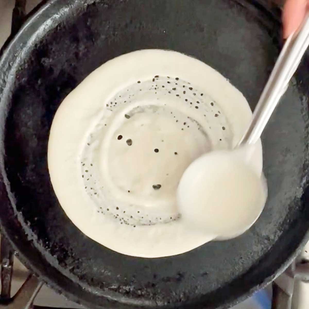 Making dosa on a wok.
