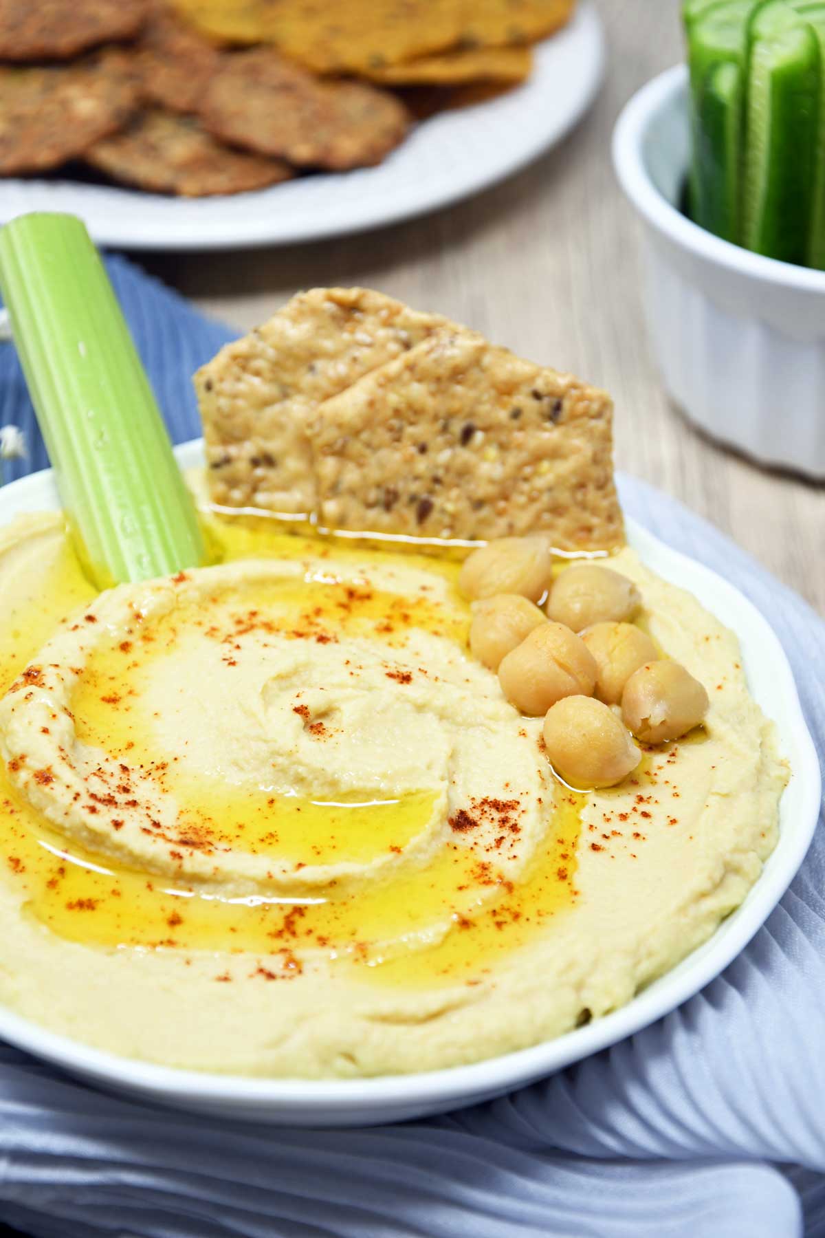 Hummus served in a shallow bowl with cracker and celery.