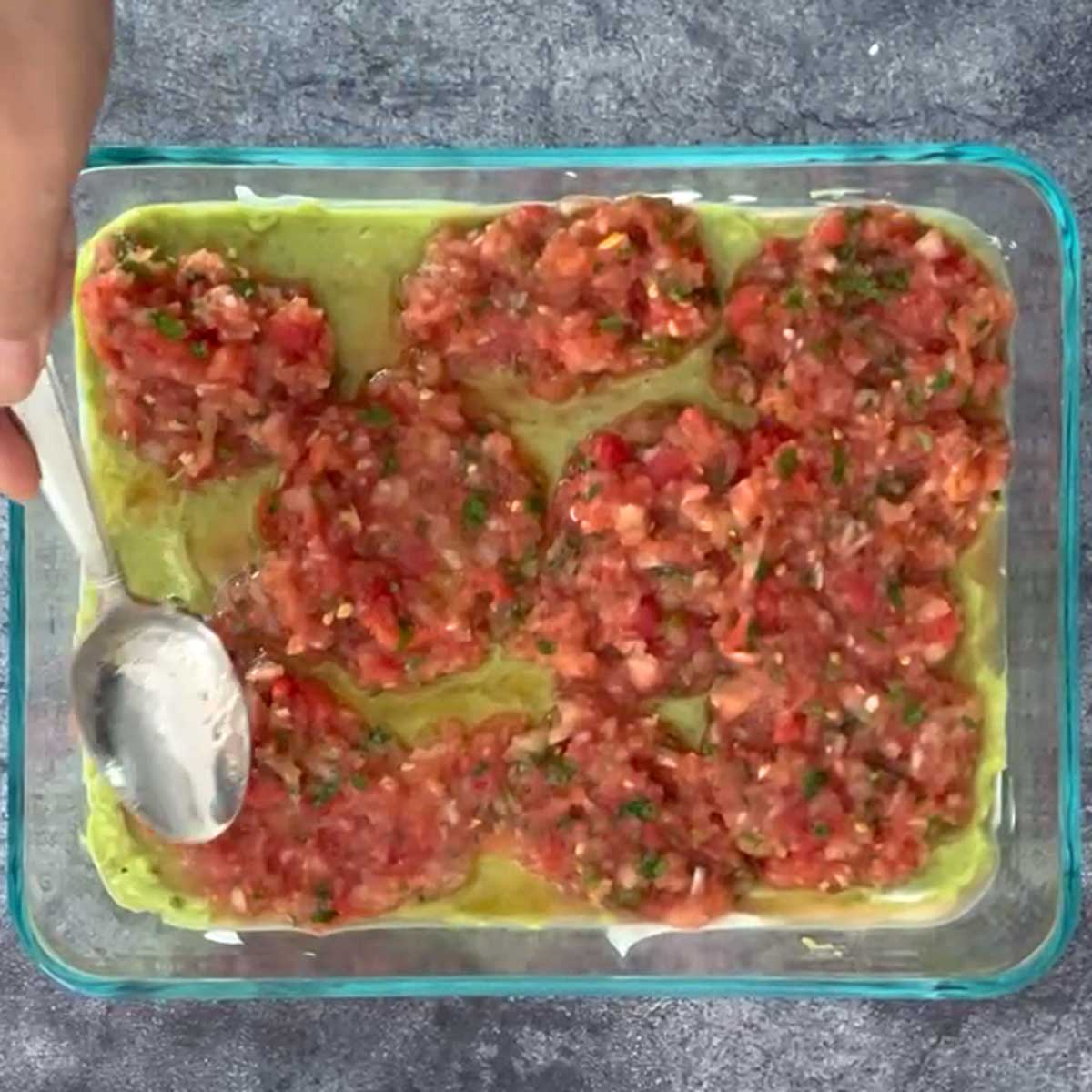 Spreading salsa for 7-layer dip.