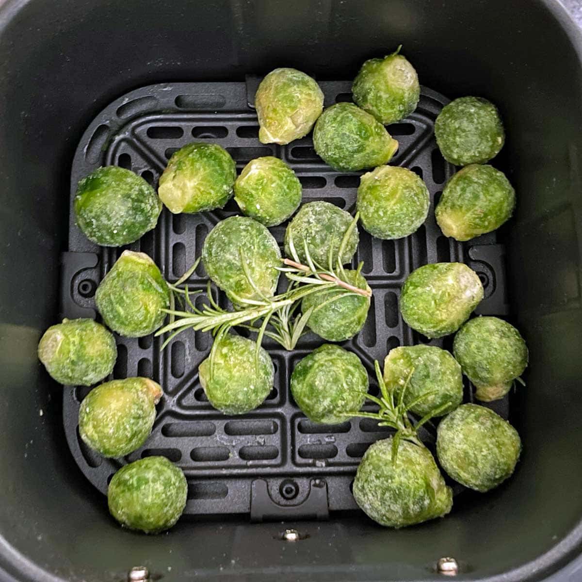 Air fryer frozen Brussels sprouts served in fryer container.