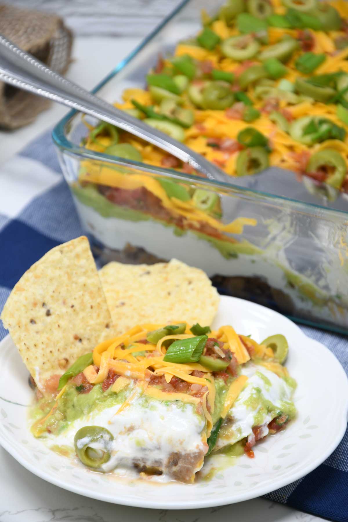 7-layer dip served on a plate with chips.