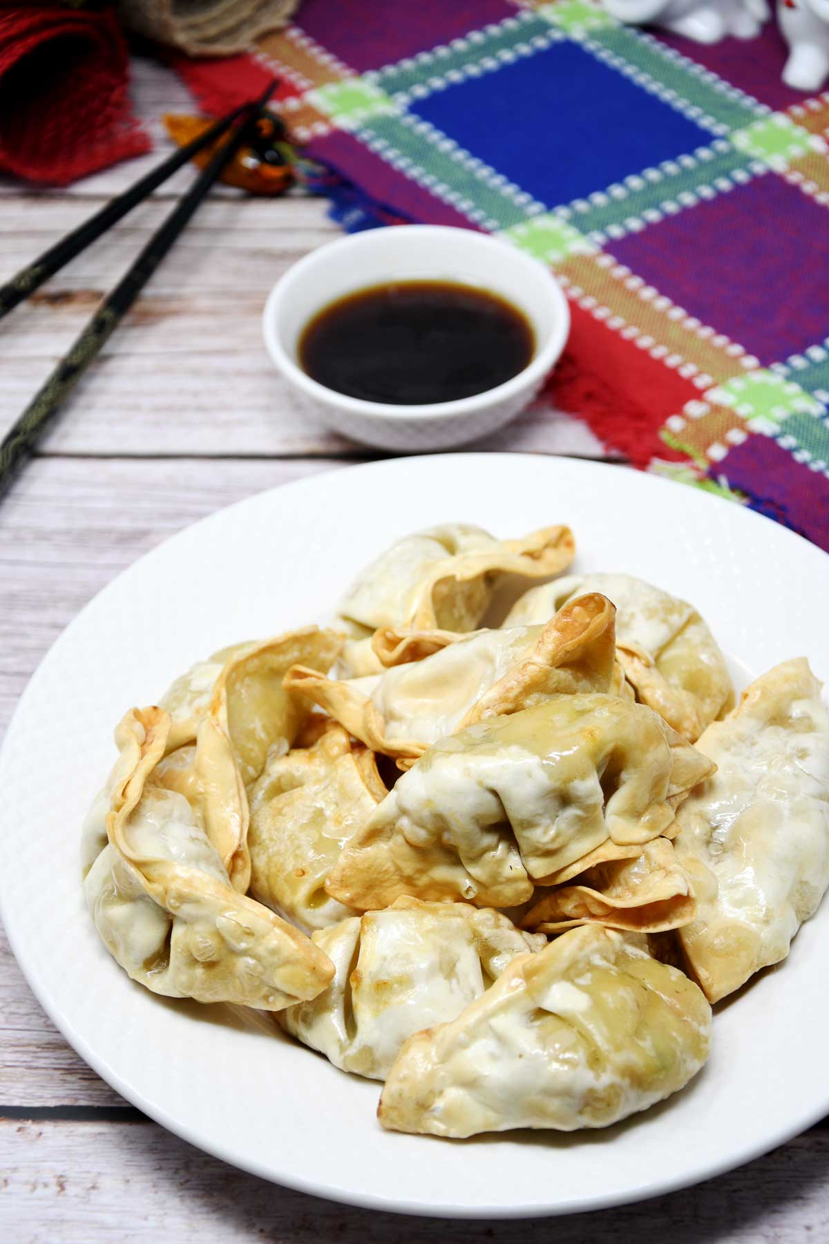 Air fryer potstickers in a plate with soy sauce on the side.