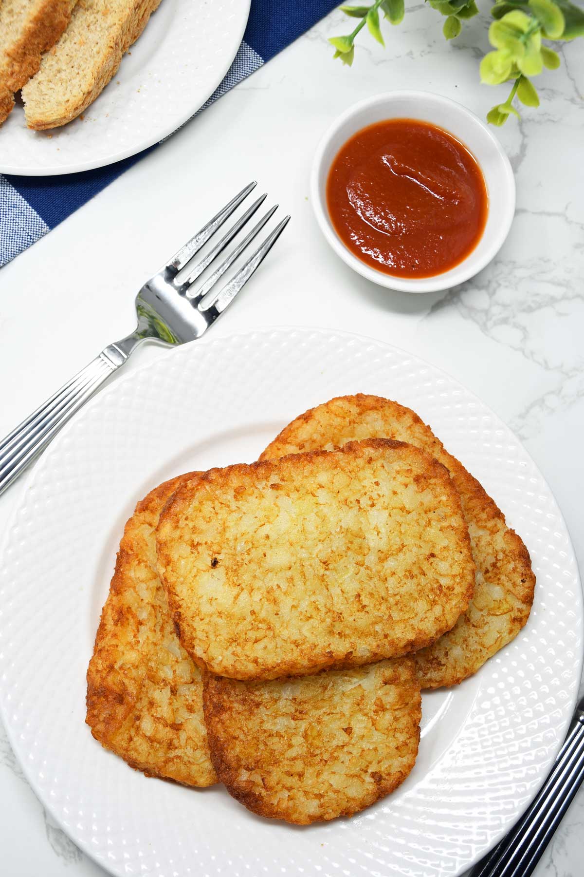 Air Fryer frozen hash browns served on a plate with ketchup.