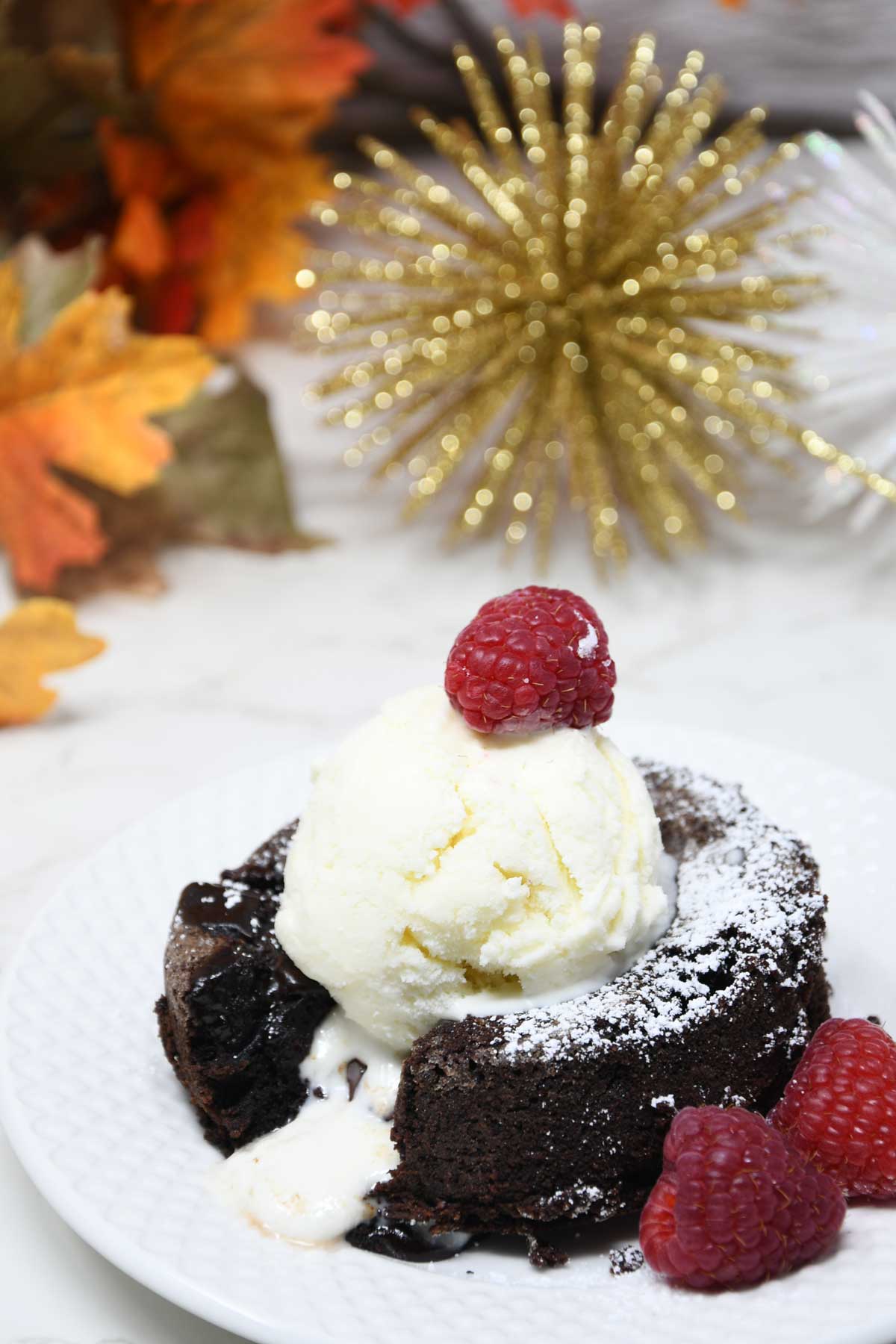 Lava cake with ice cream and raspberry topping.