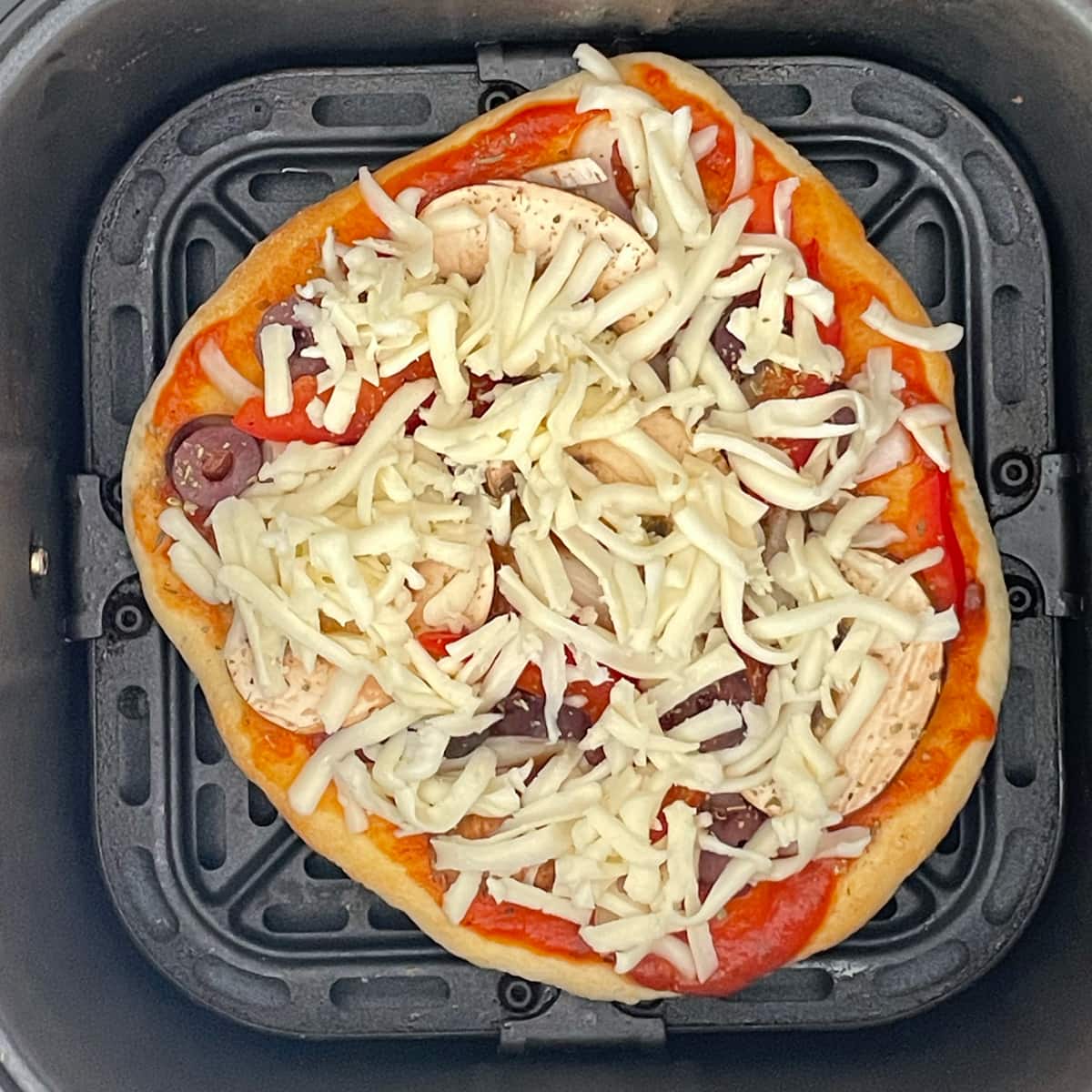 Pizza base with all toppings ready to bake.