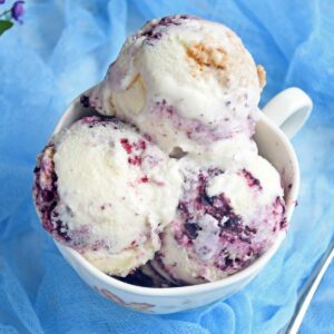 Blueberry cheesecake ice-cream scoops in a bowl.