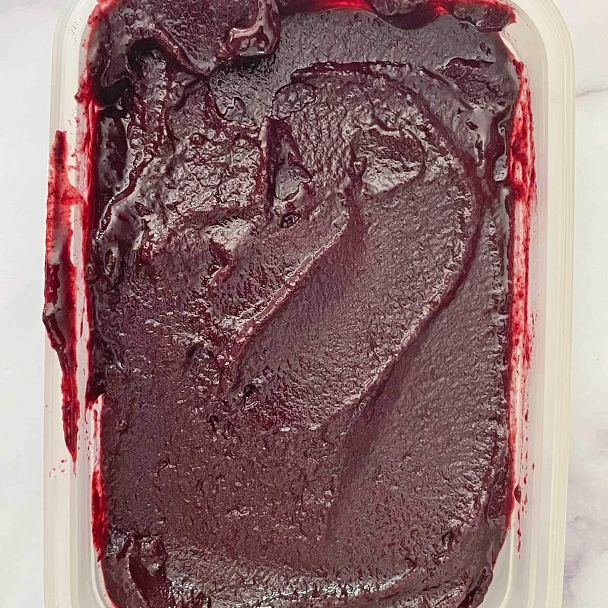 Churned Blueberry sorbet mix in a container.