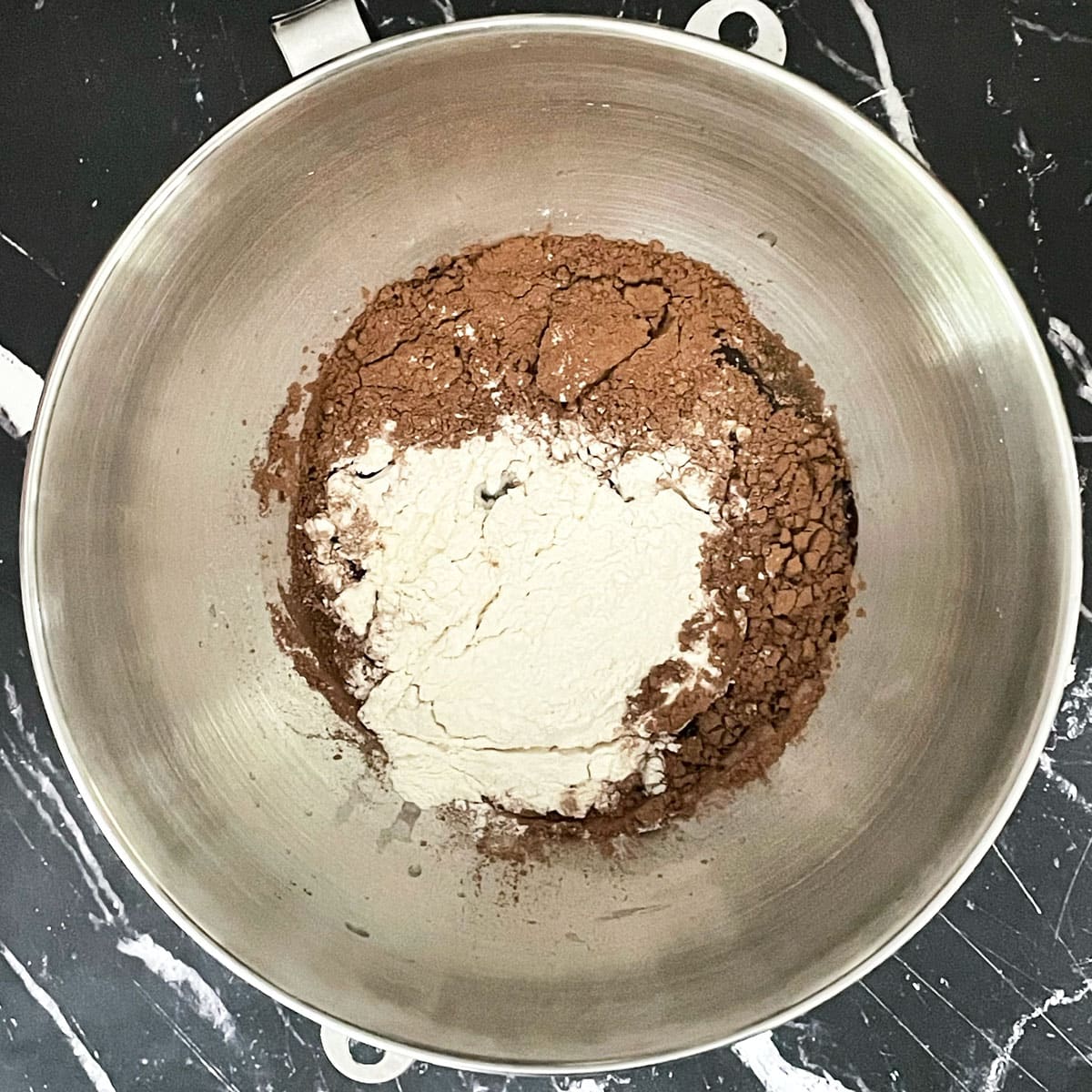 Chocolate cake wet and dry ingredients in mixer bowl.