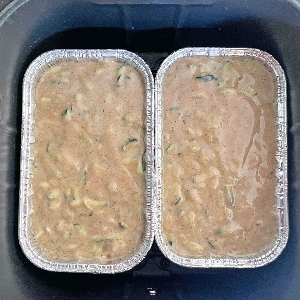 Zucchini bread batter in loaf pans.