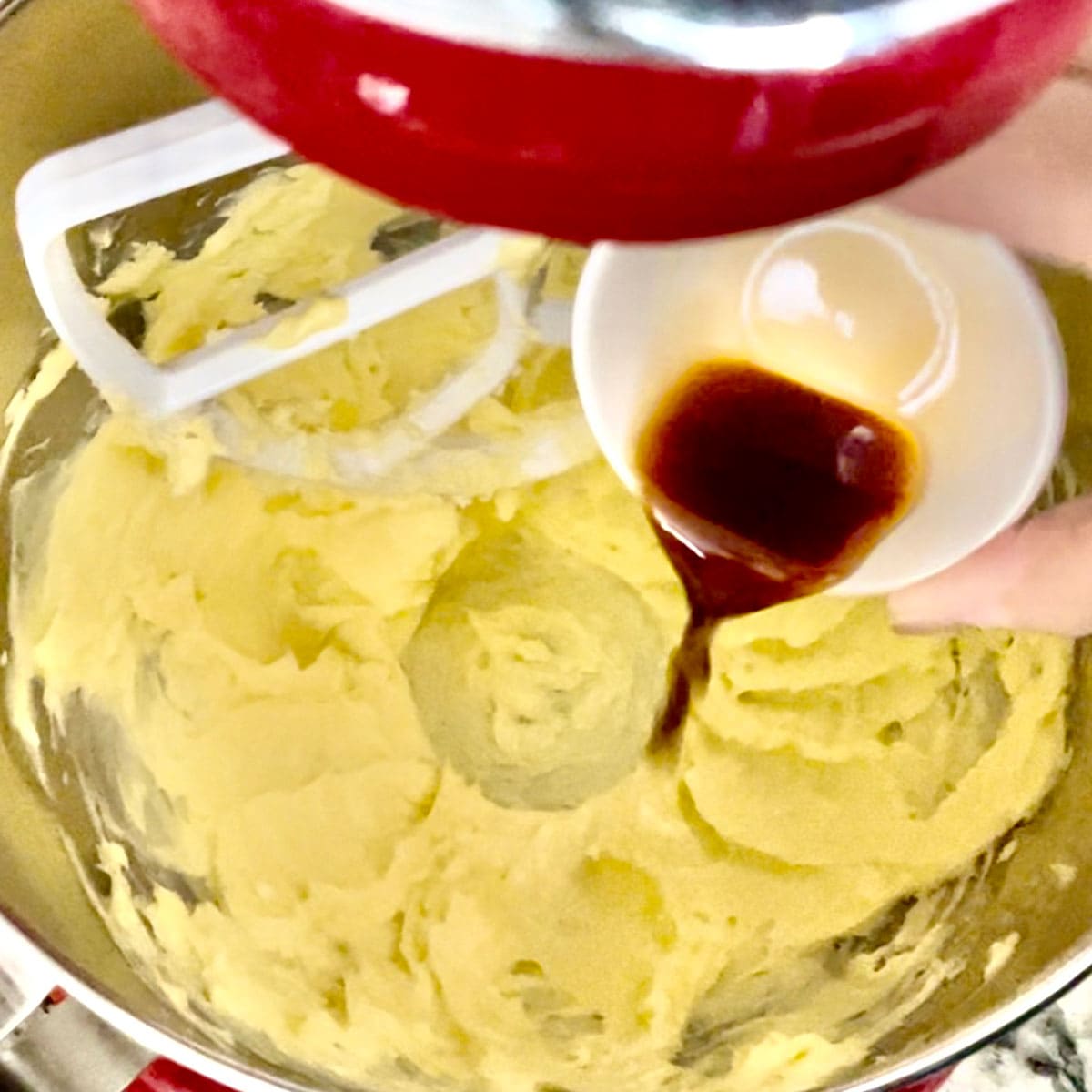Fluffed butter and vanilla extract in mixing bowl.