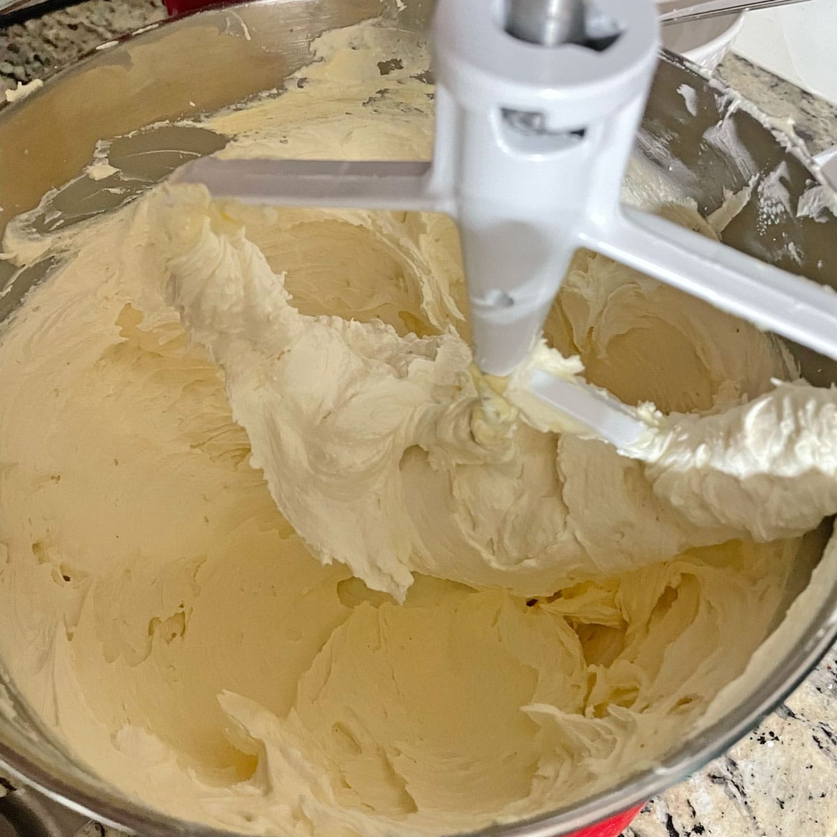 Butter cream frosting in mixing bowl.