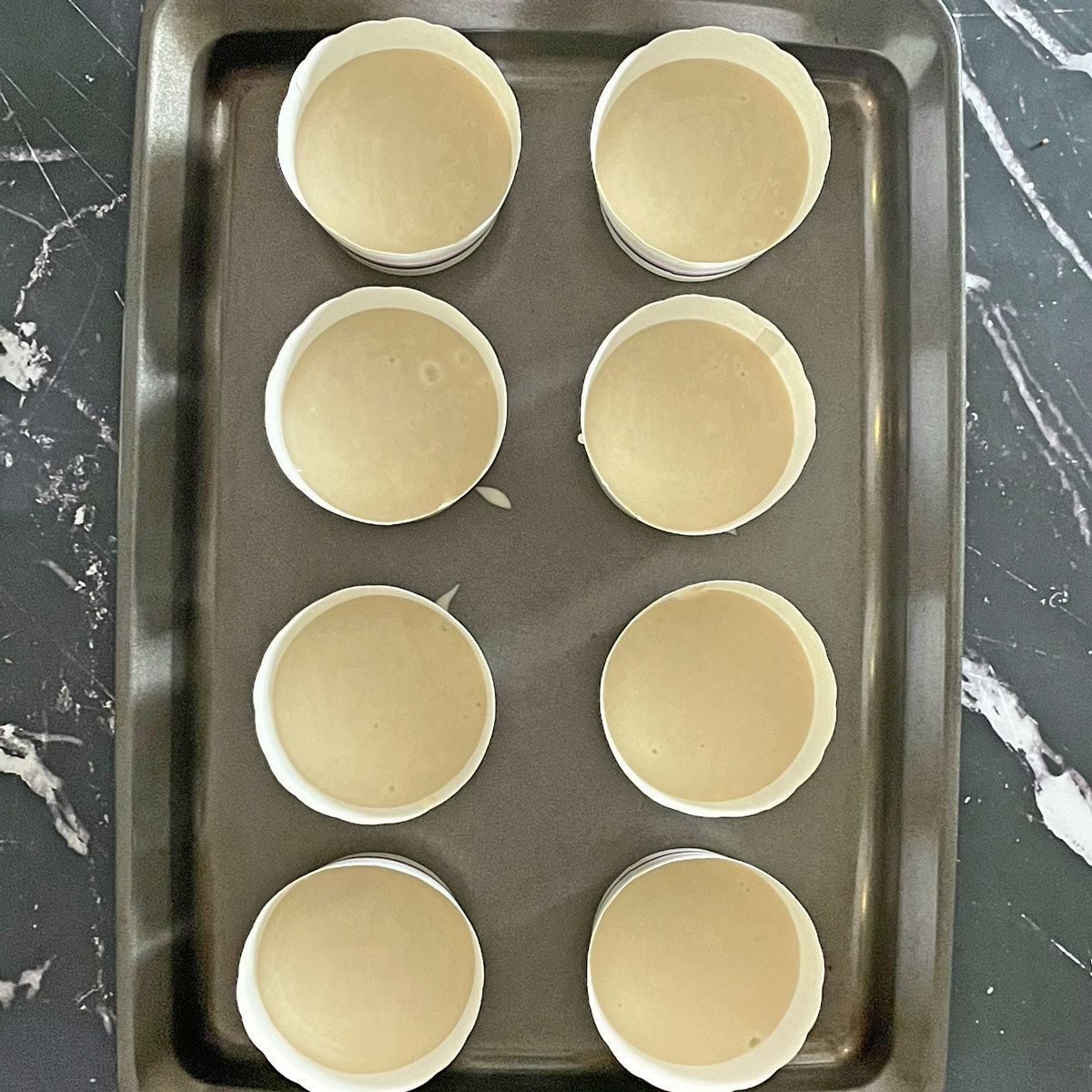 Vanilla cupcake batter in molds.