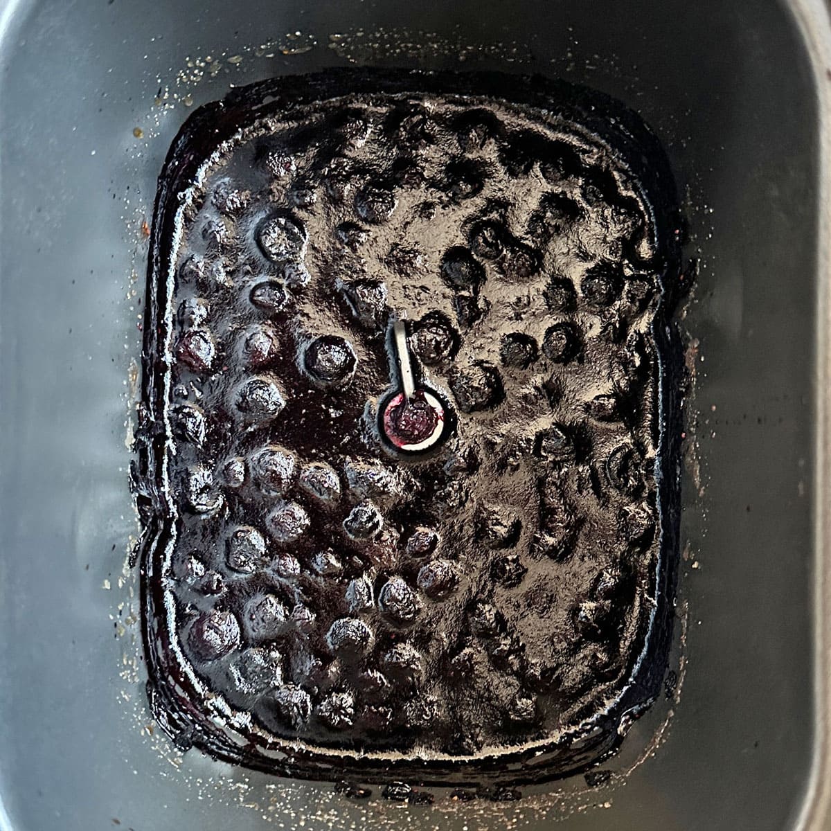 Cooked blueberry jam in bread pan.