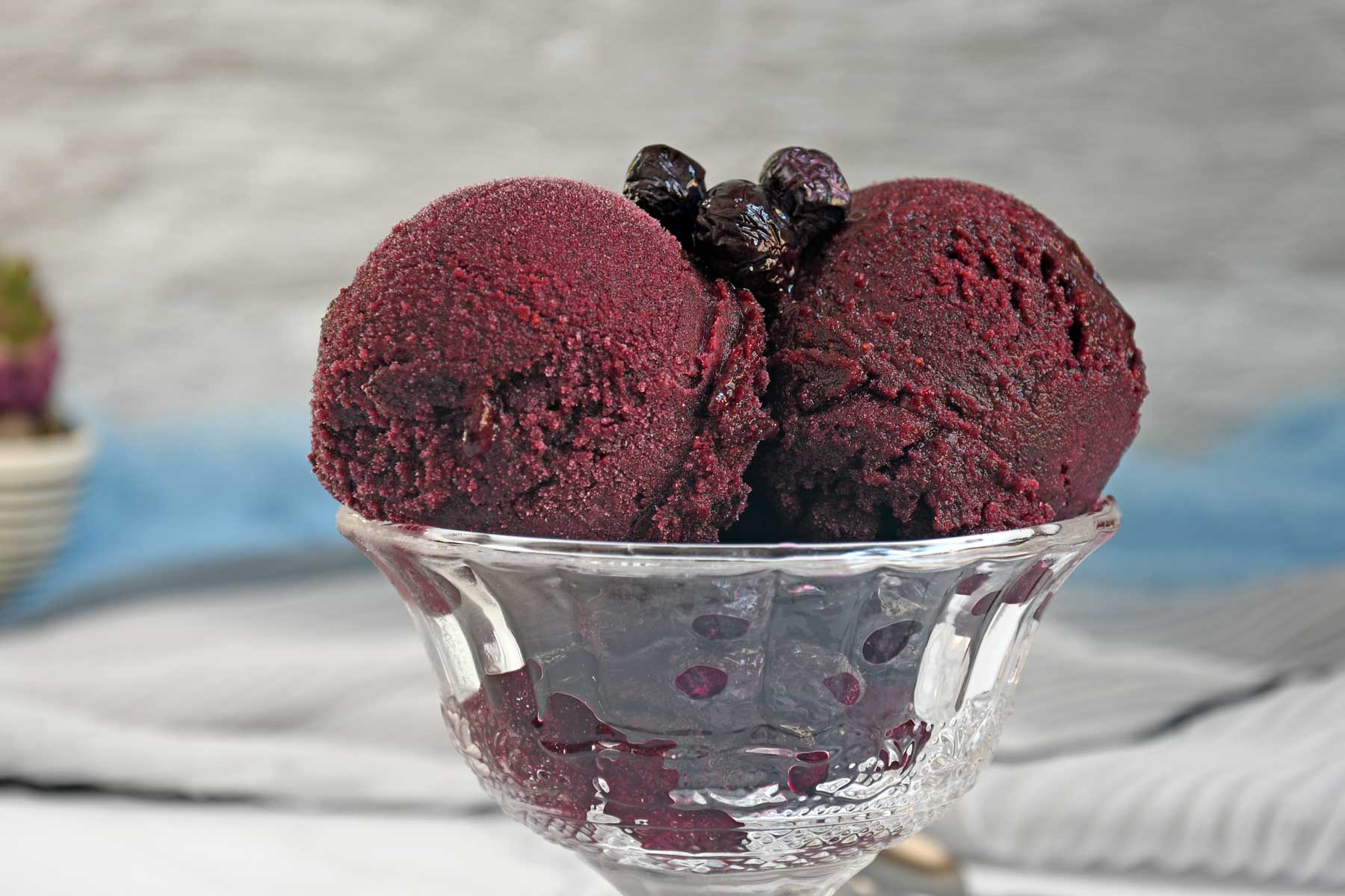 Blueberry Sorbet scoops in a glass bowl.