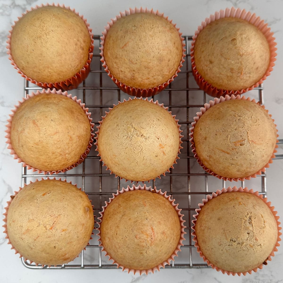 Carrot cupcakes on cooling rack.