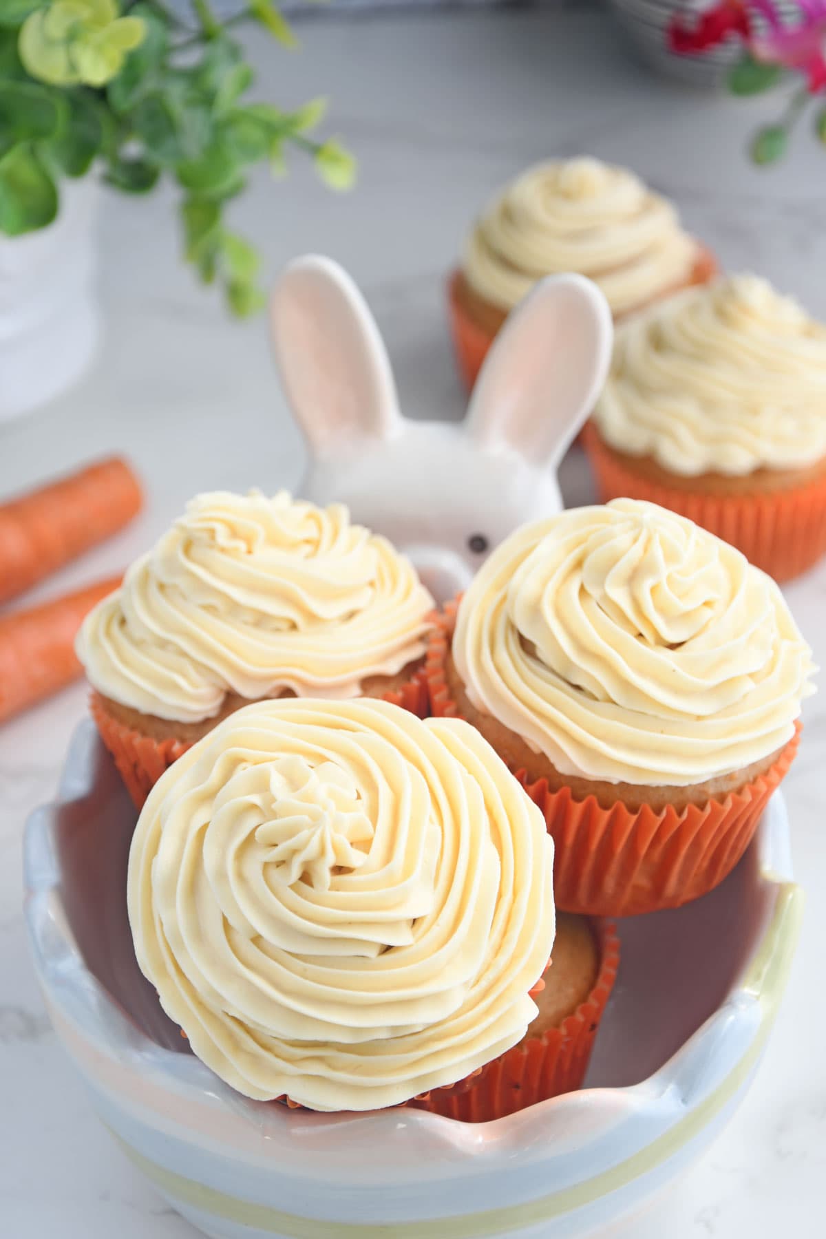 Carrot cupcakes in a decorative bowl.
