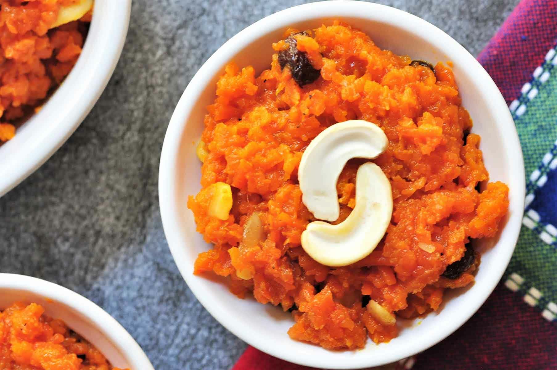 Carrot Halwa in a bowl and garnished with split cashew nut.